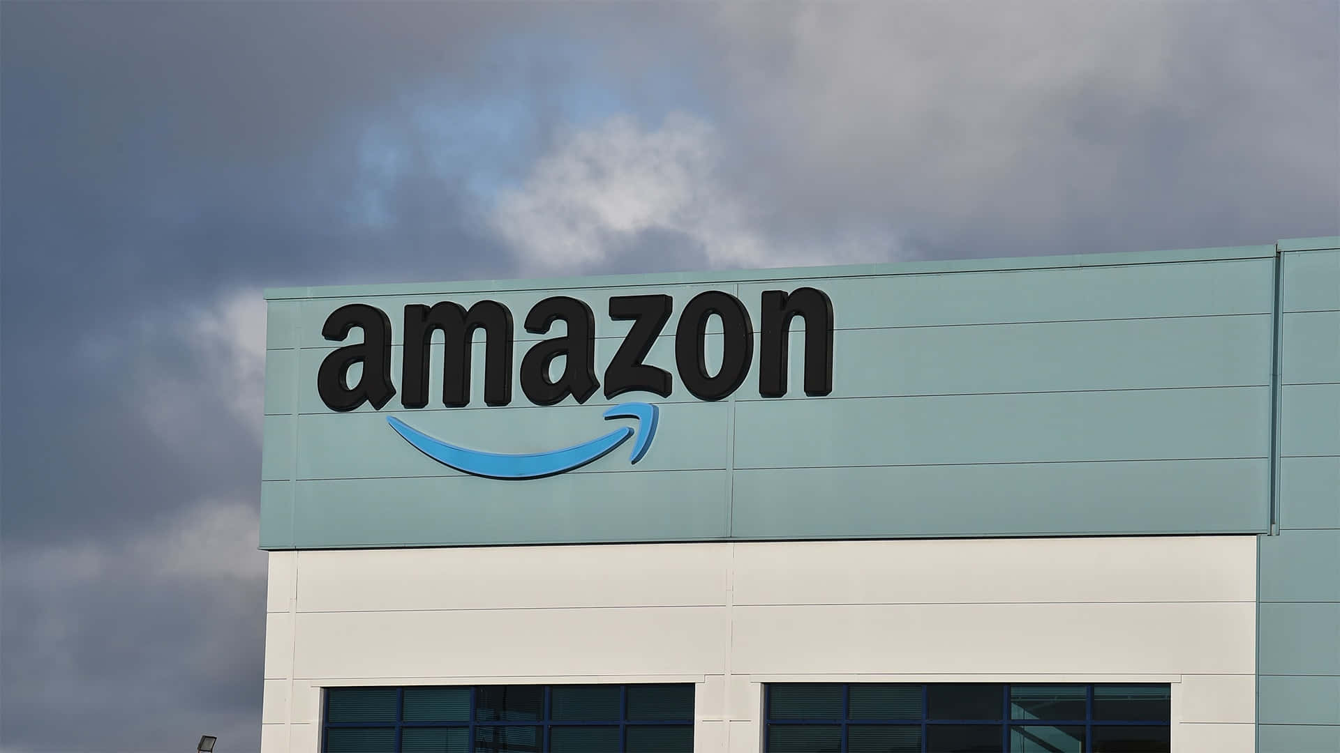 Logotipode Amazon Uk En Un Edificio De Color Teal Claro. Fondo de pantalla
