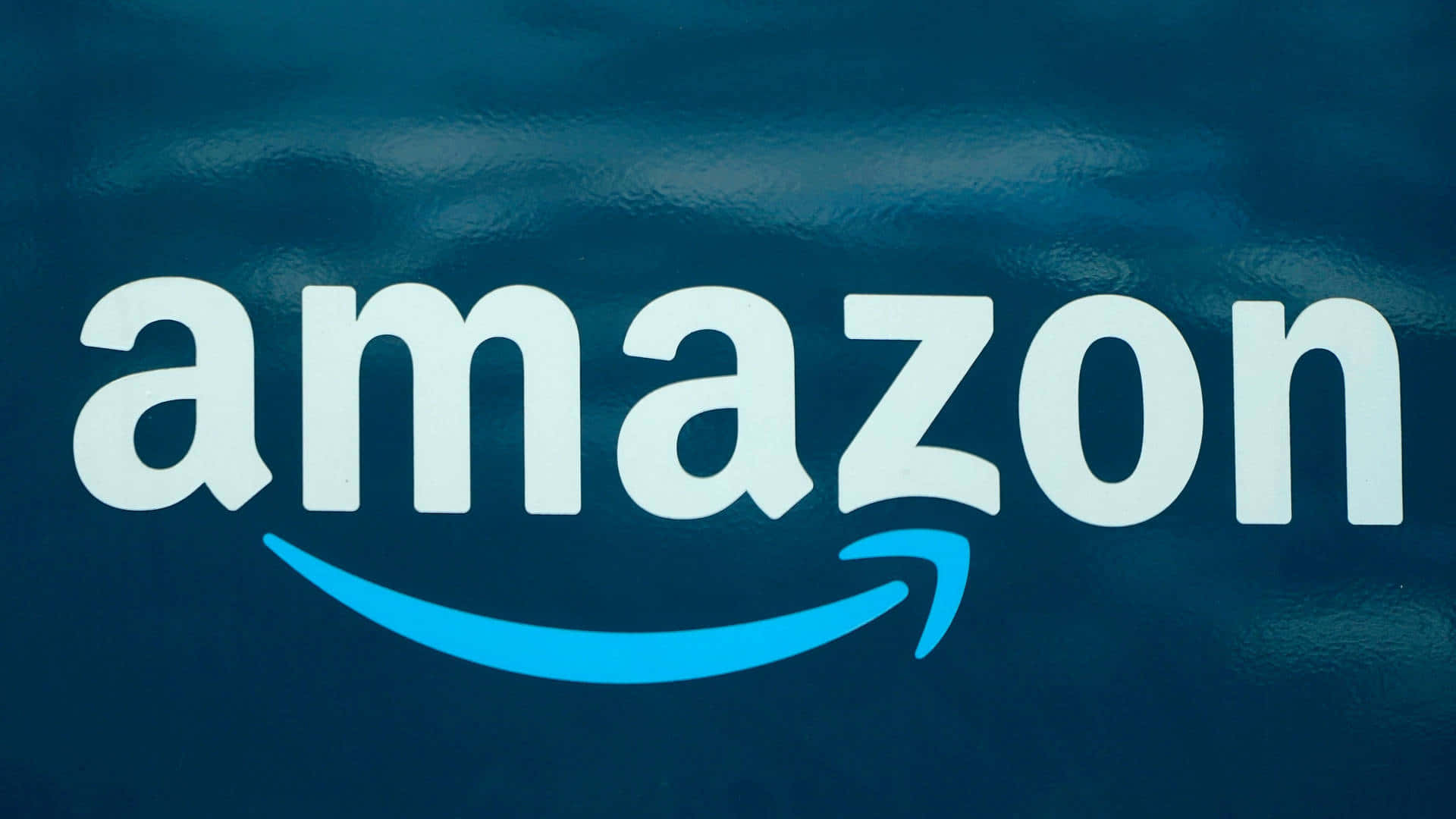Amazon UK's iconic logo featuring a blue arrow Wallpaper