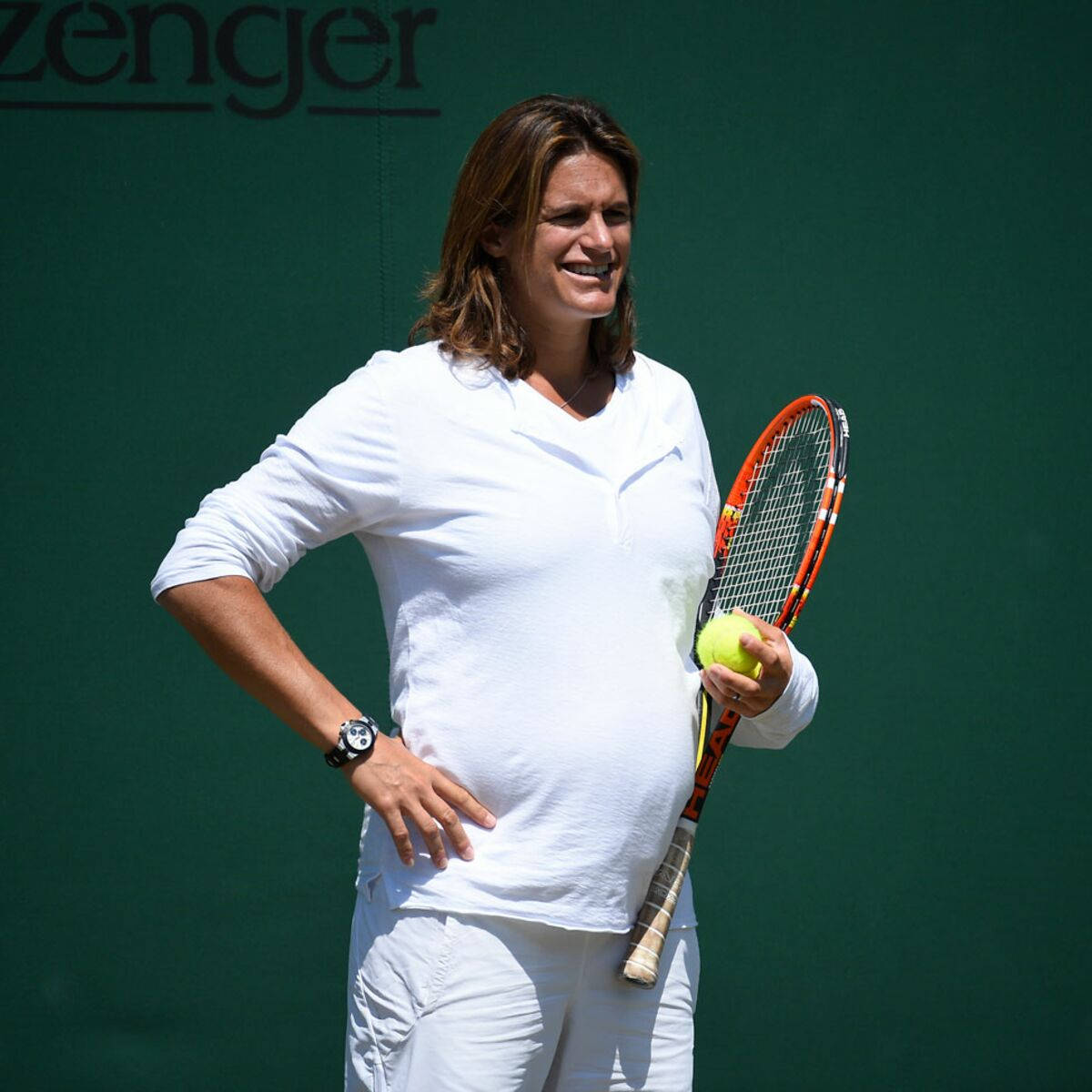 Amélie Mauresmo observing on the sidelines during a tennis match. Wallpaper