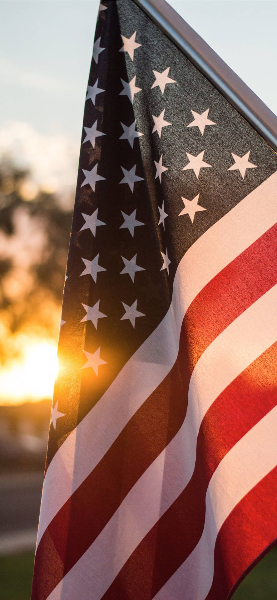 Sonnenunterganghinter Der Amerikanischen Flagge Auf Dem Iphone Wallpaper
