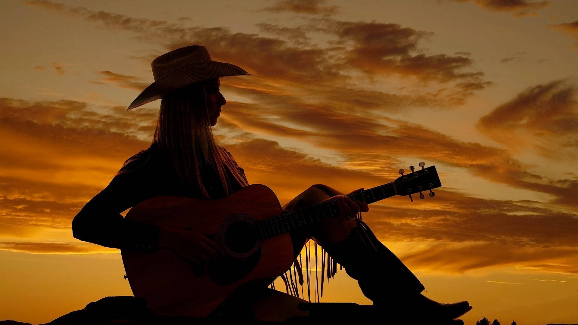 Eincowboy Reitet In Den Sonnenuntergang. Wallpaper