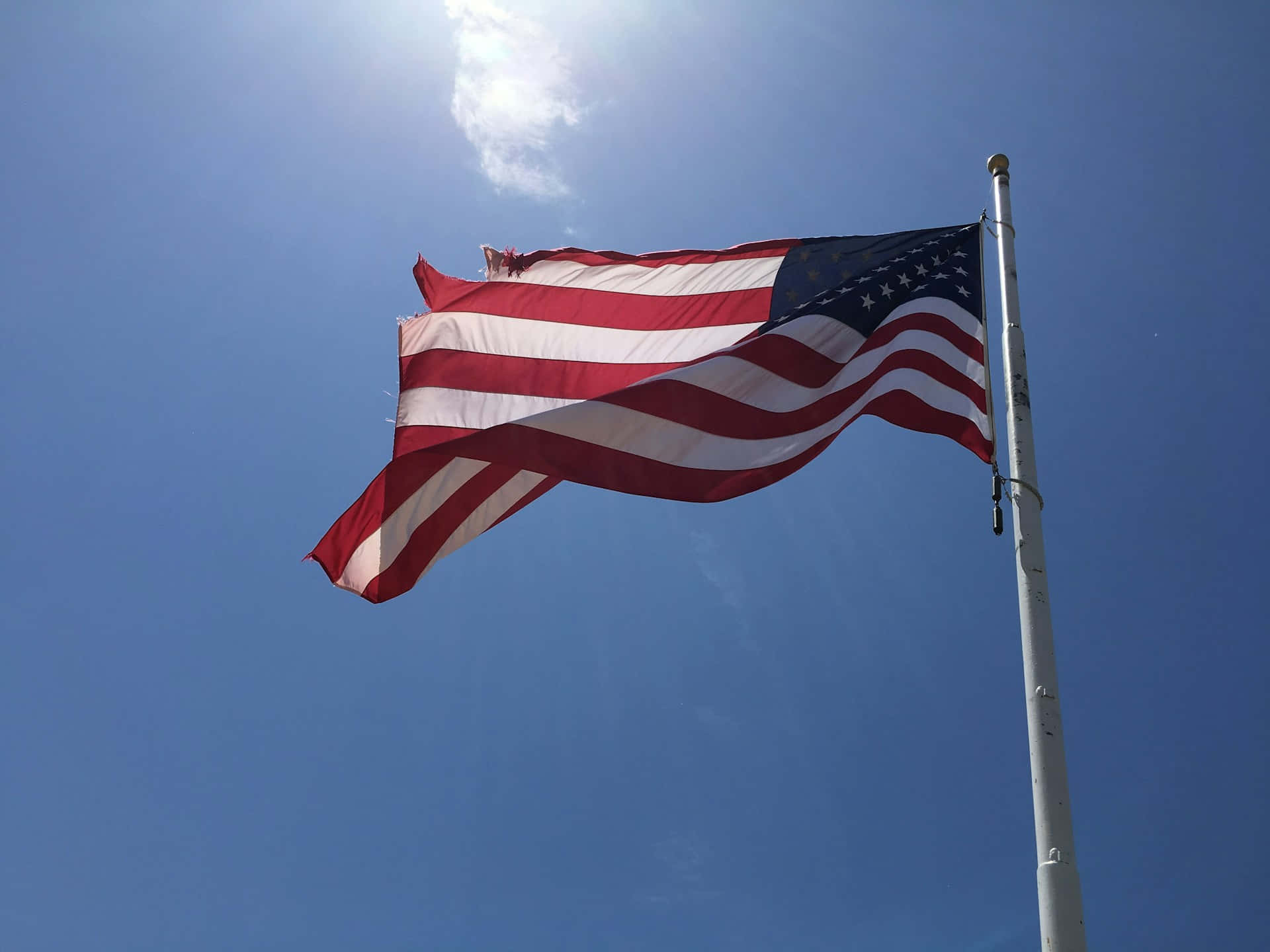 American Flag Waving Against Blue Sky Wallpaper