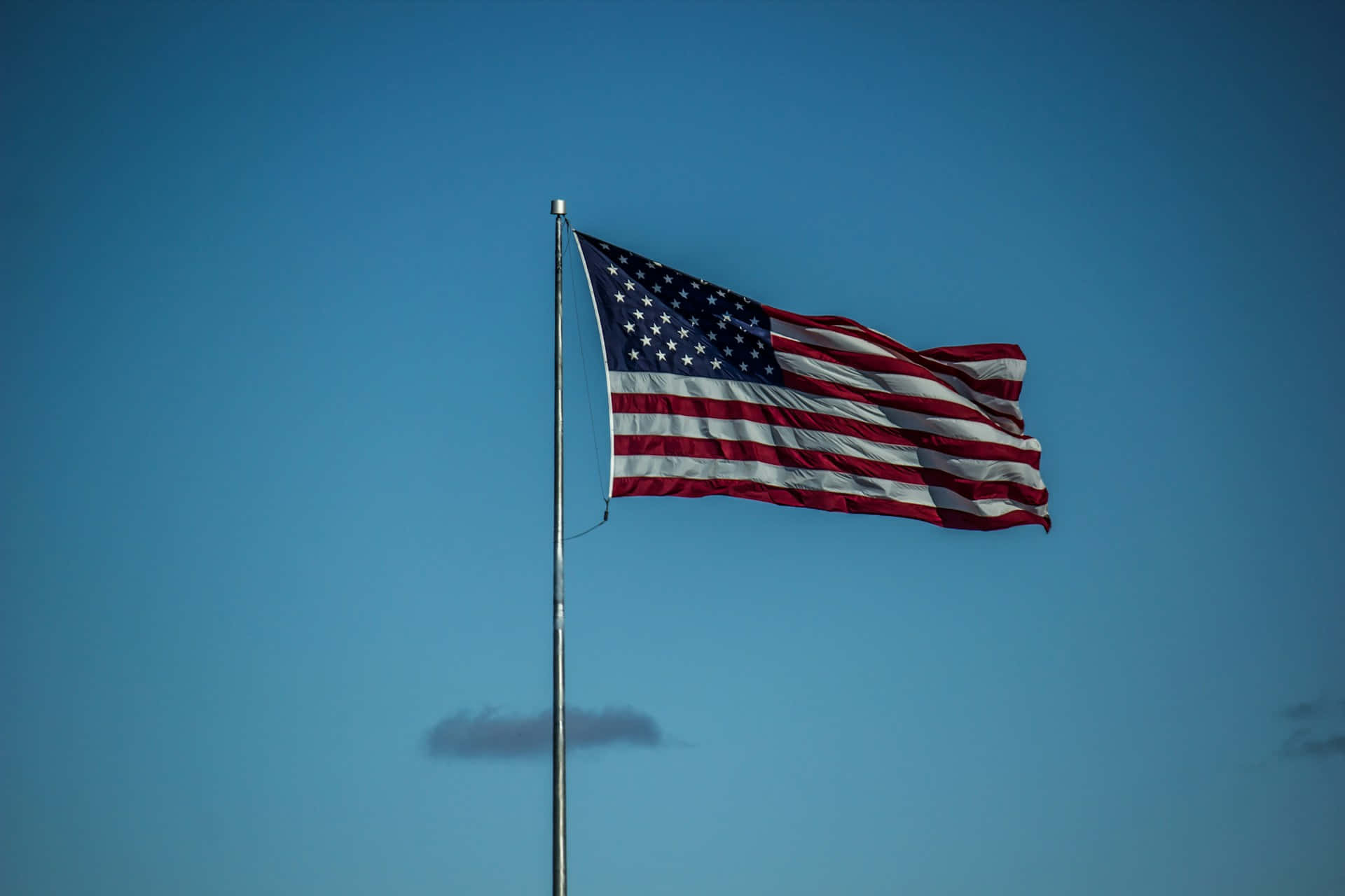 American Flag Waving Against Blue Sky Wallpaper