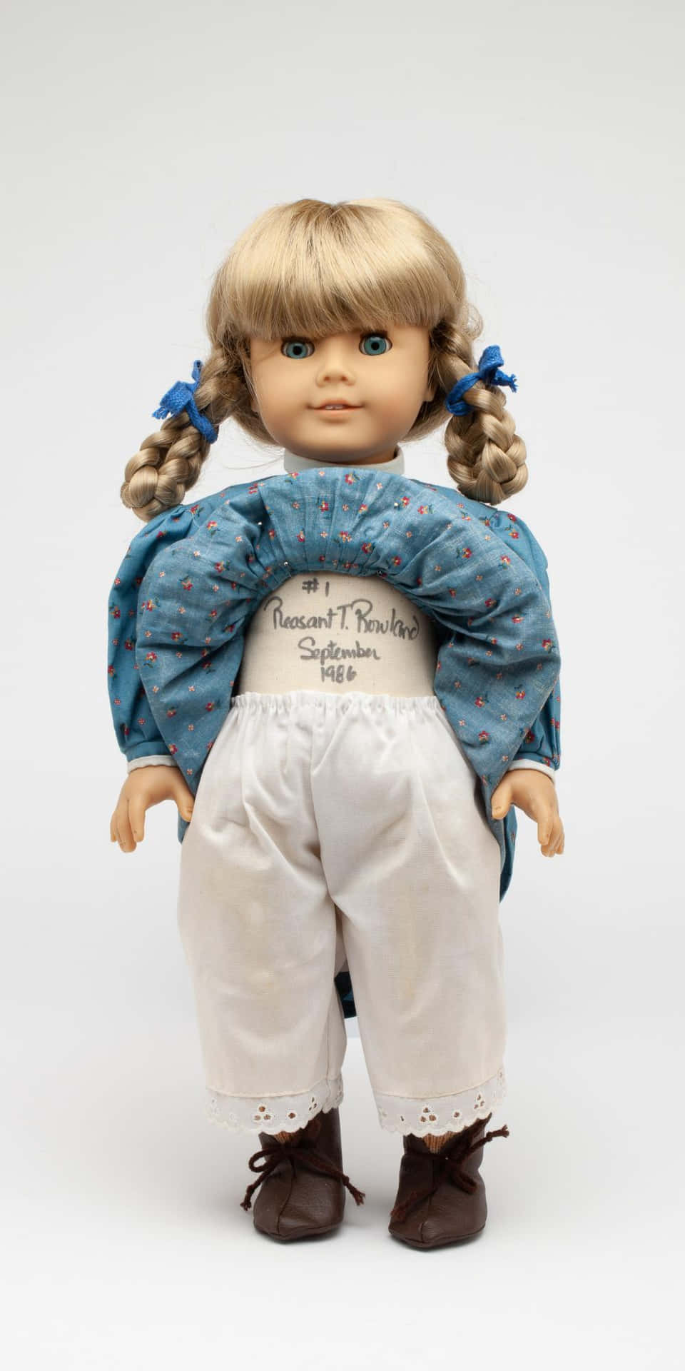 A Doll With Blonde Hair And Blue Pants