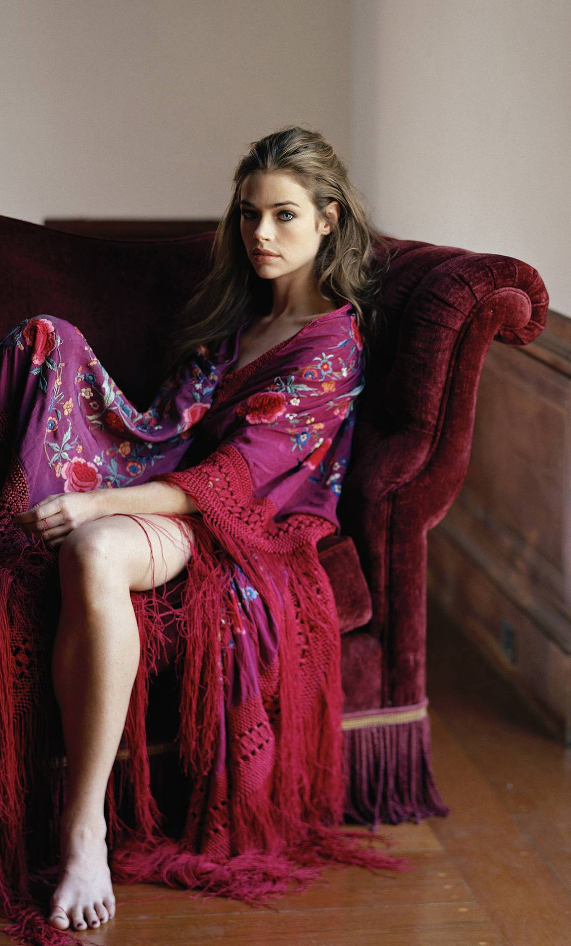 Modeloamericana Denise Richards Posando En Un Sofá De Terciopelo. Fondo de pantalla