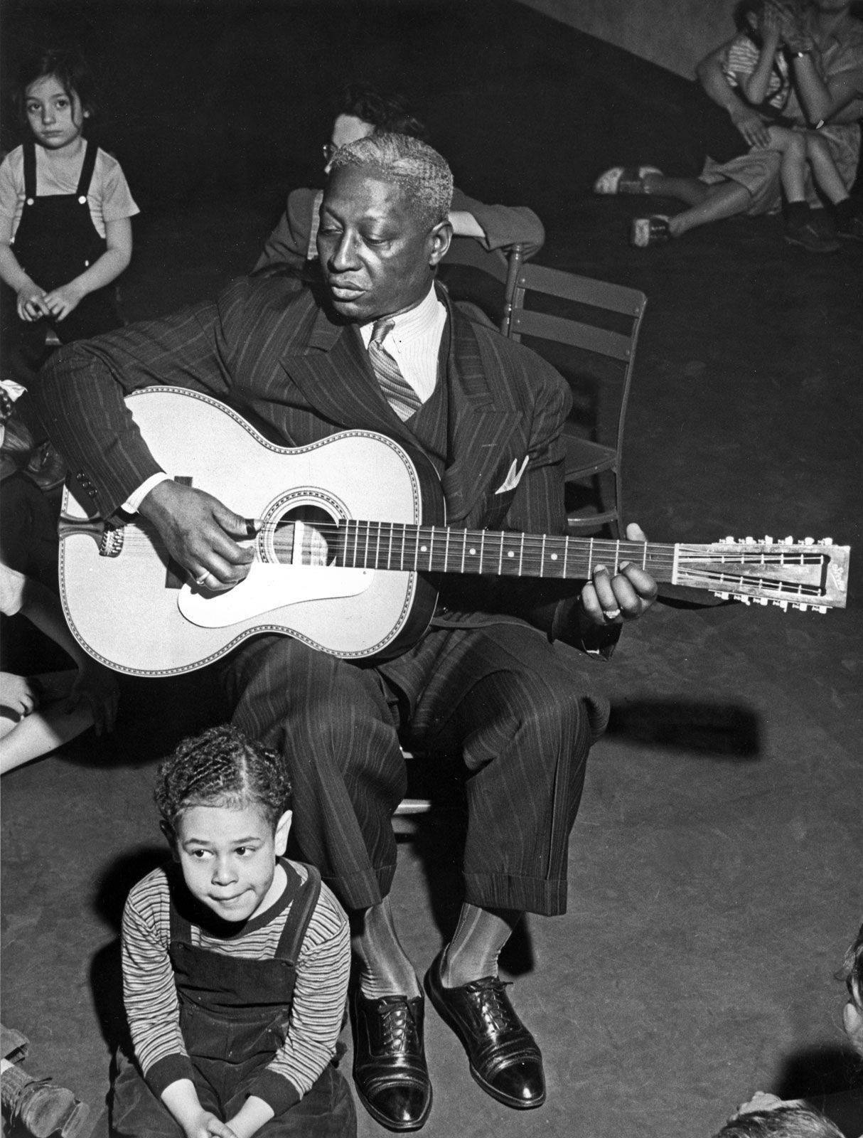 American Singer And Musician Leadbelly With Kids 1940s Photograph Wallpaper