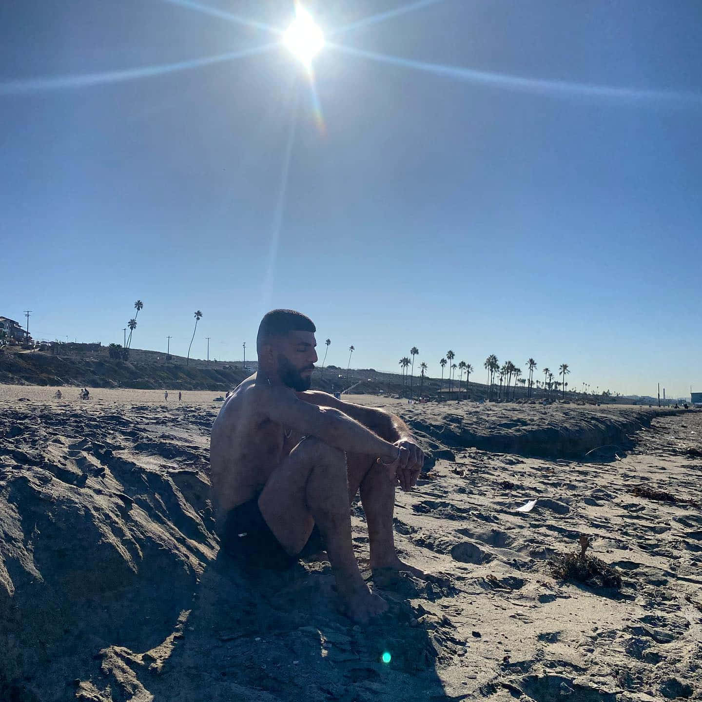 Amir Albazi Sitting On Sandy Beach Picture