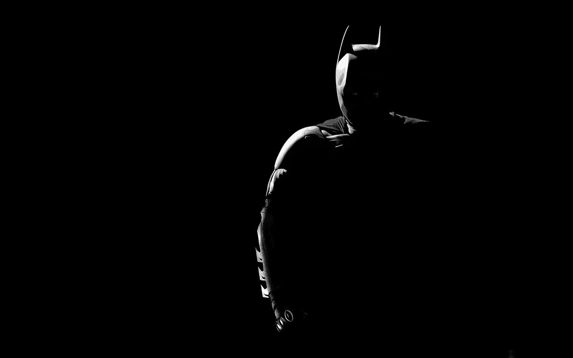Batman In The Dark Silhouetted Against A Black Background Wallpaper