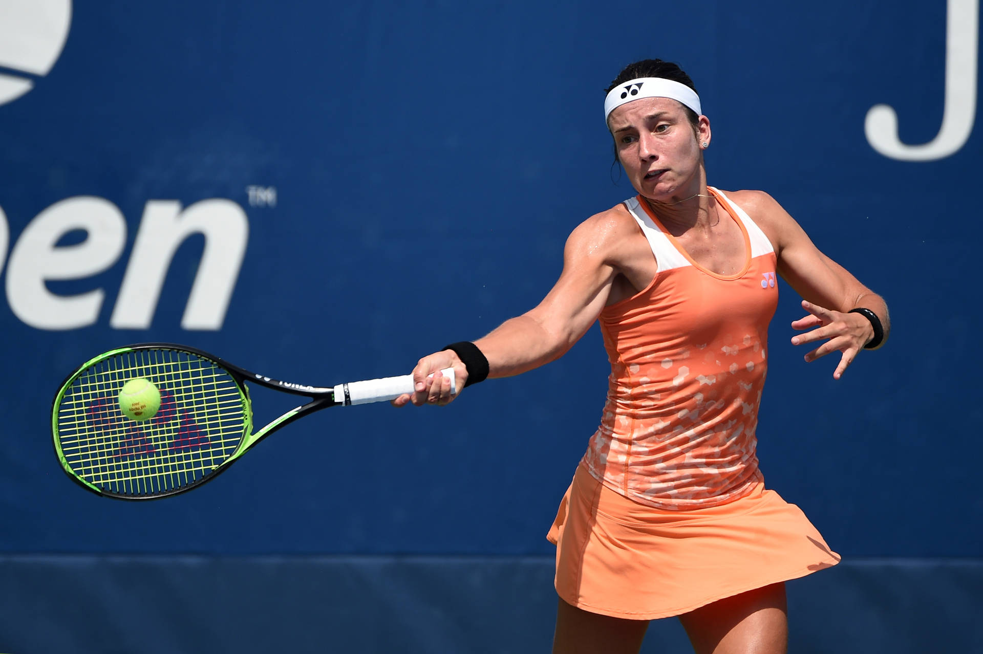 Anastasija Sevastova Dominating the Court in Peach Tennis Dress Wallpaper