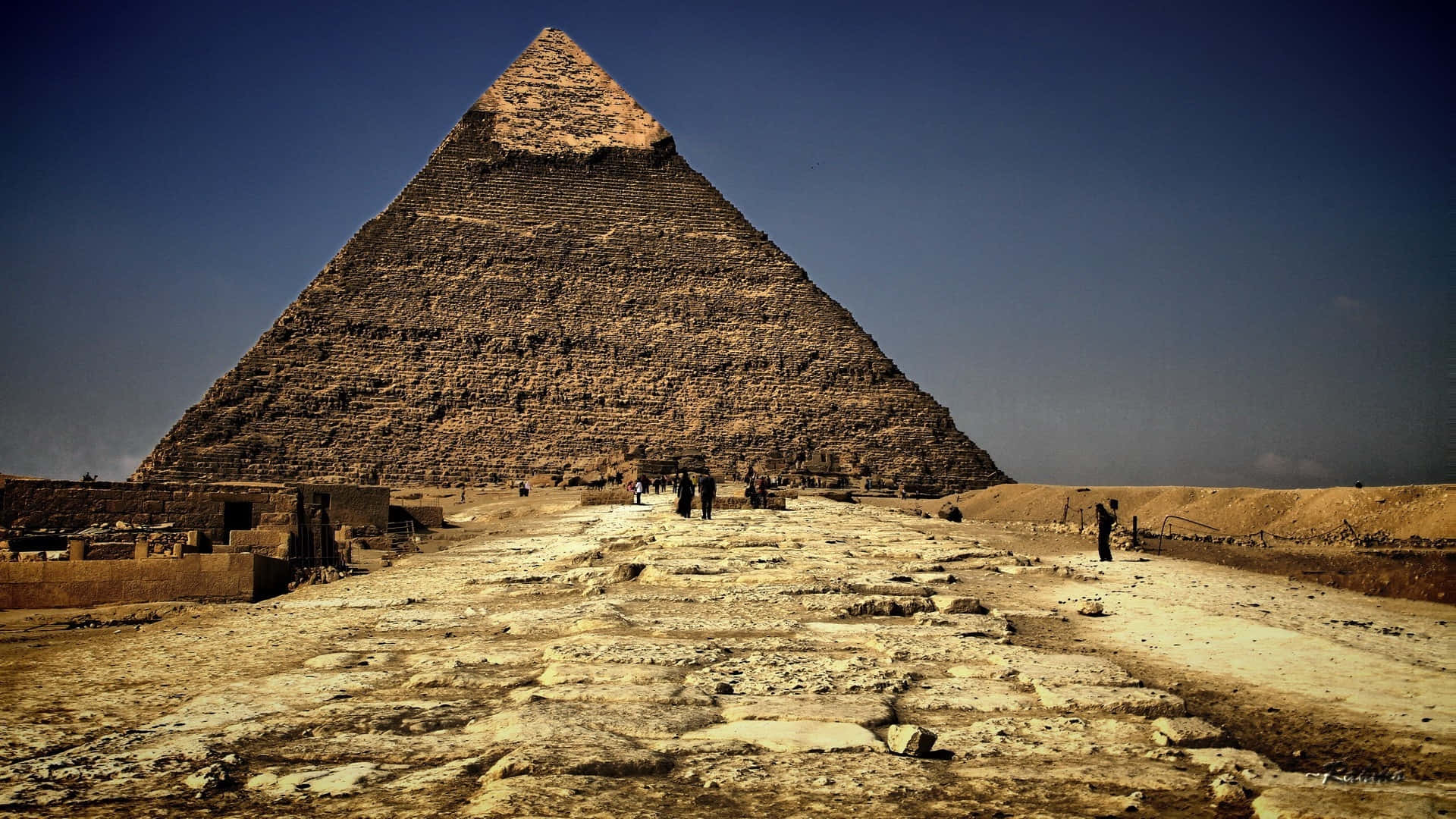 En stor pyramide med mennesker går rundt om den Wallpaper