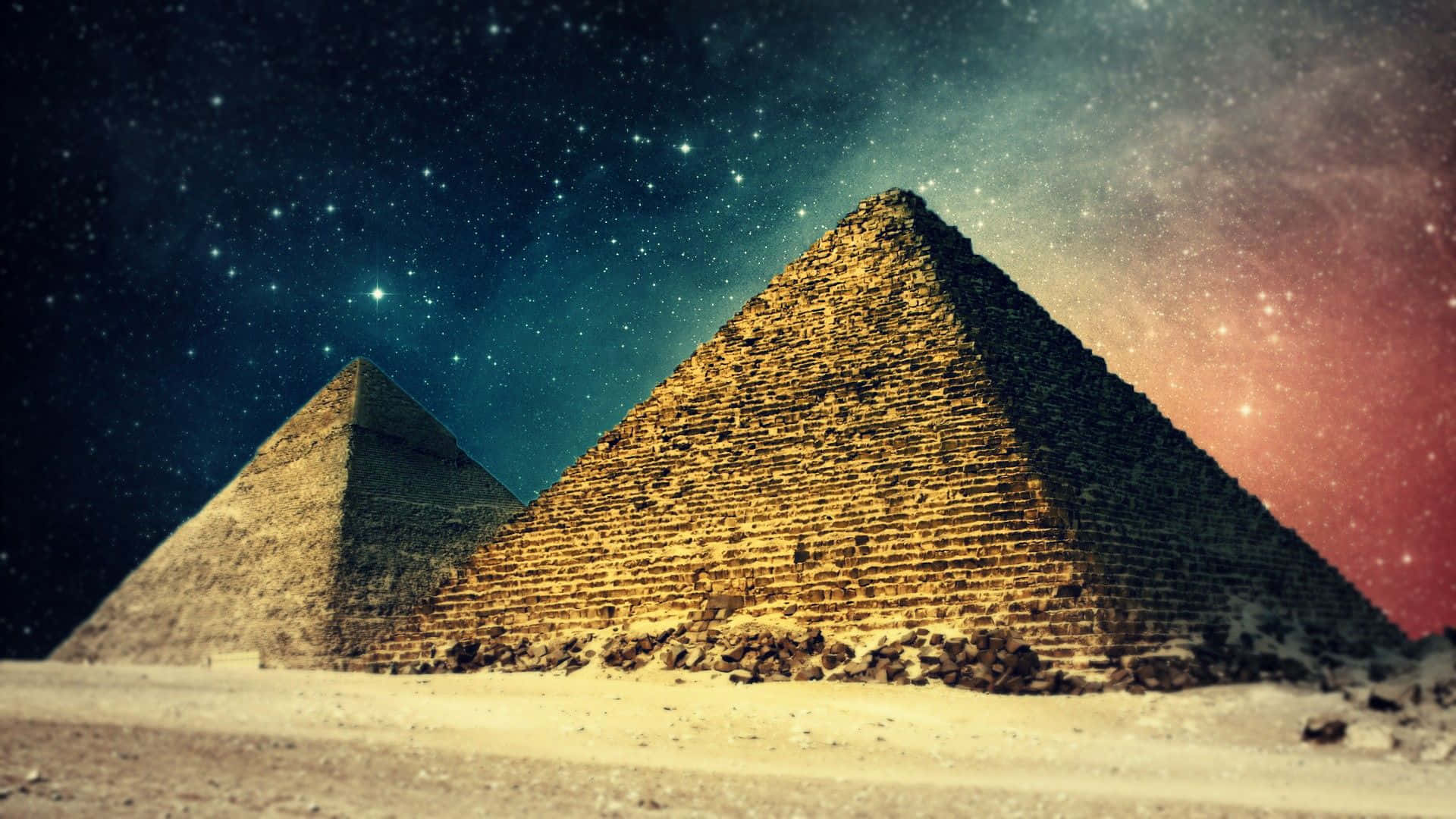 Tre pyramider i ørkenen med stjerner på himlen Wallpaper