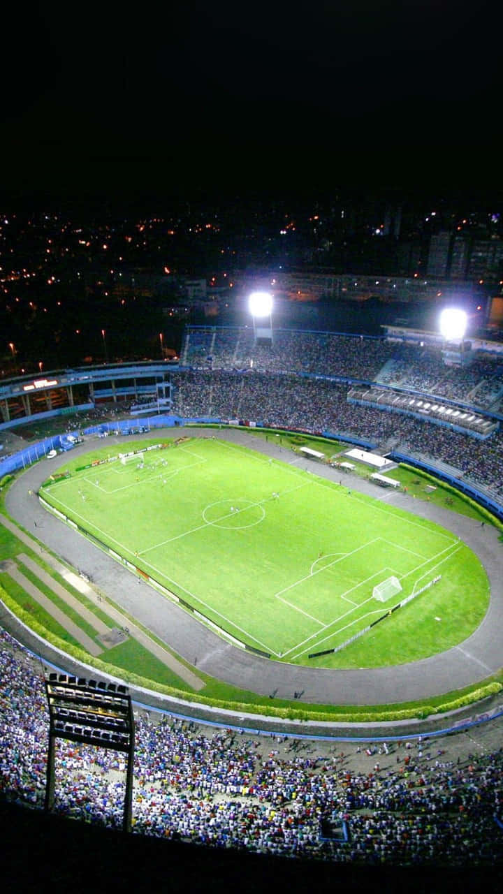 Unestadio De Fútbol Por La Noche Con Muchas Personas Mirando