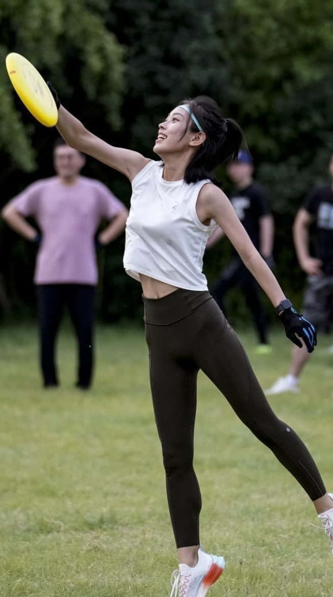 Sfondocon Immagine Di Una Donna Atleta Durante Una Partita Di Ultimate Frisbee Su Android.