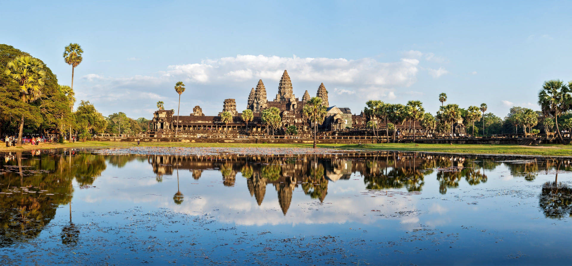 Caption: Majestic View of Angkor Wat Reflecting Under the Azure Sky Wallpaper