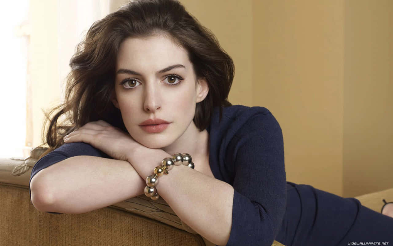 Anne Hathaway With A Serious Face While Posing Wallpaper