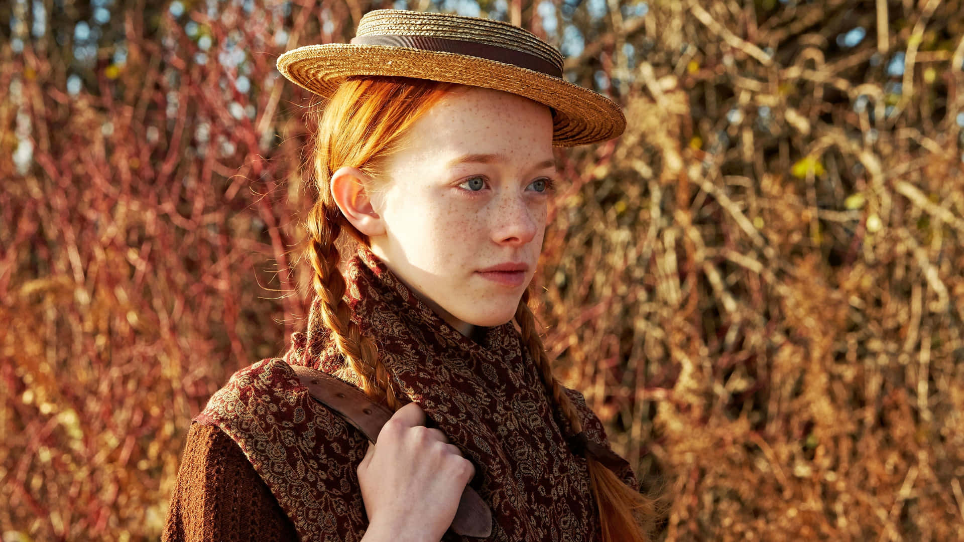 A Young Girl In A Brown Hat Is Standing In A Field