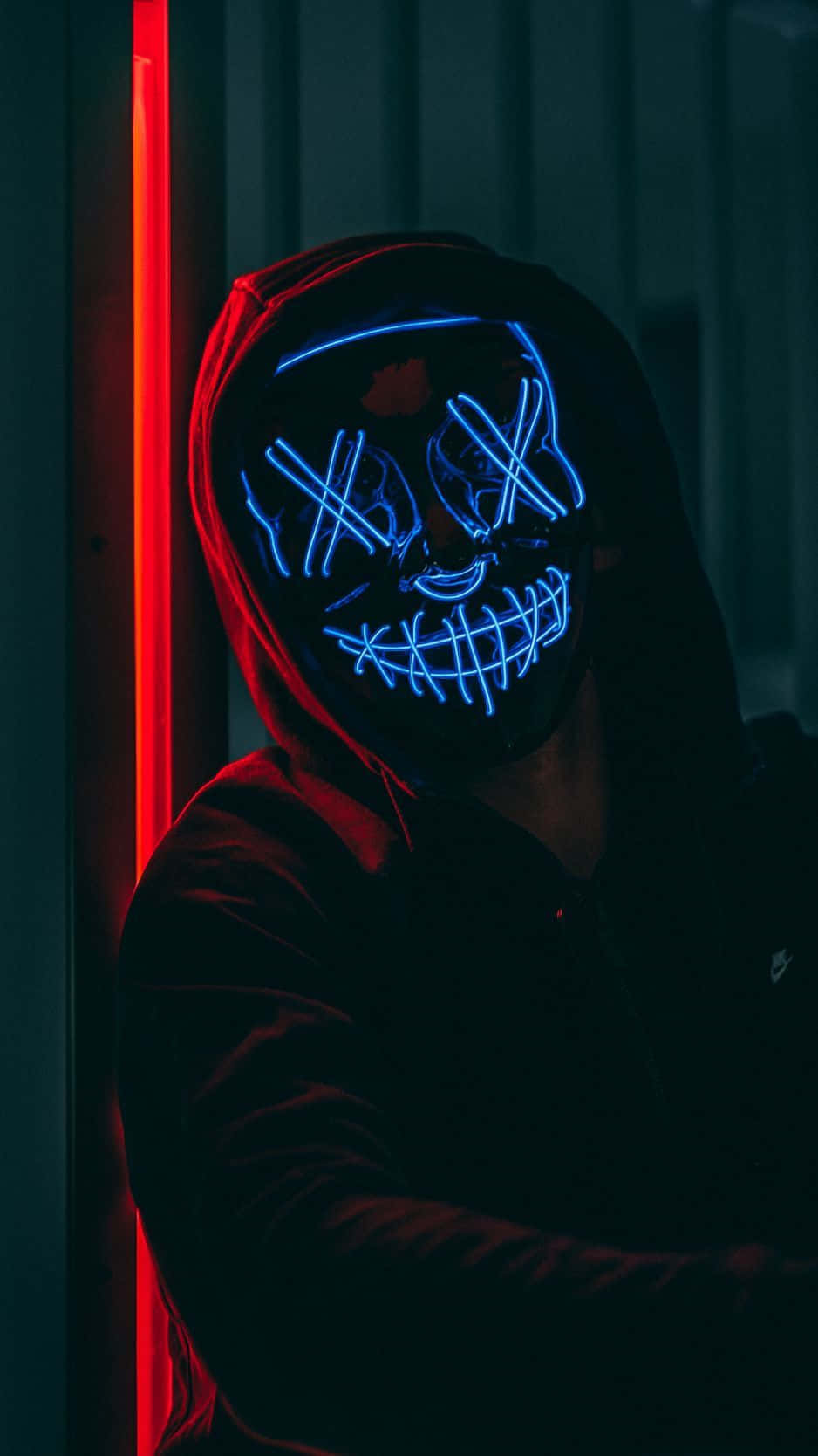 Einmann Trägt Eine Leuchtende Neonmaske In Einem Dunklen Raum. Wallpaper