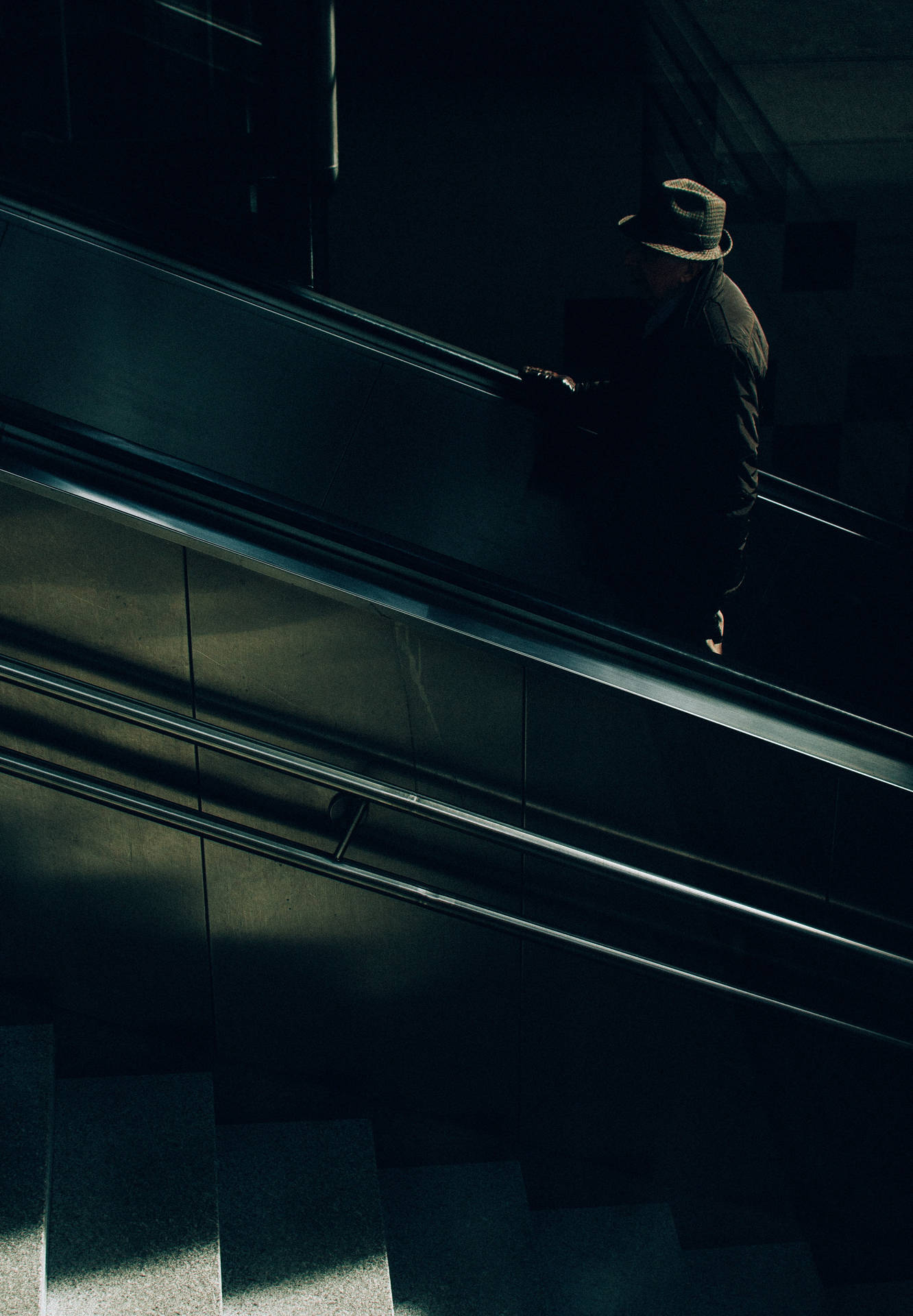Anonymous Man Riding an Escalator Wallpaper