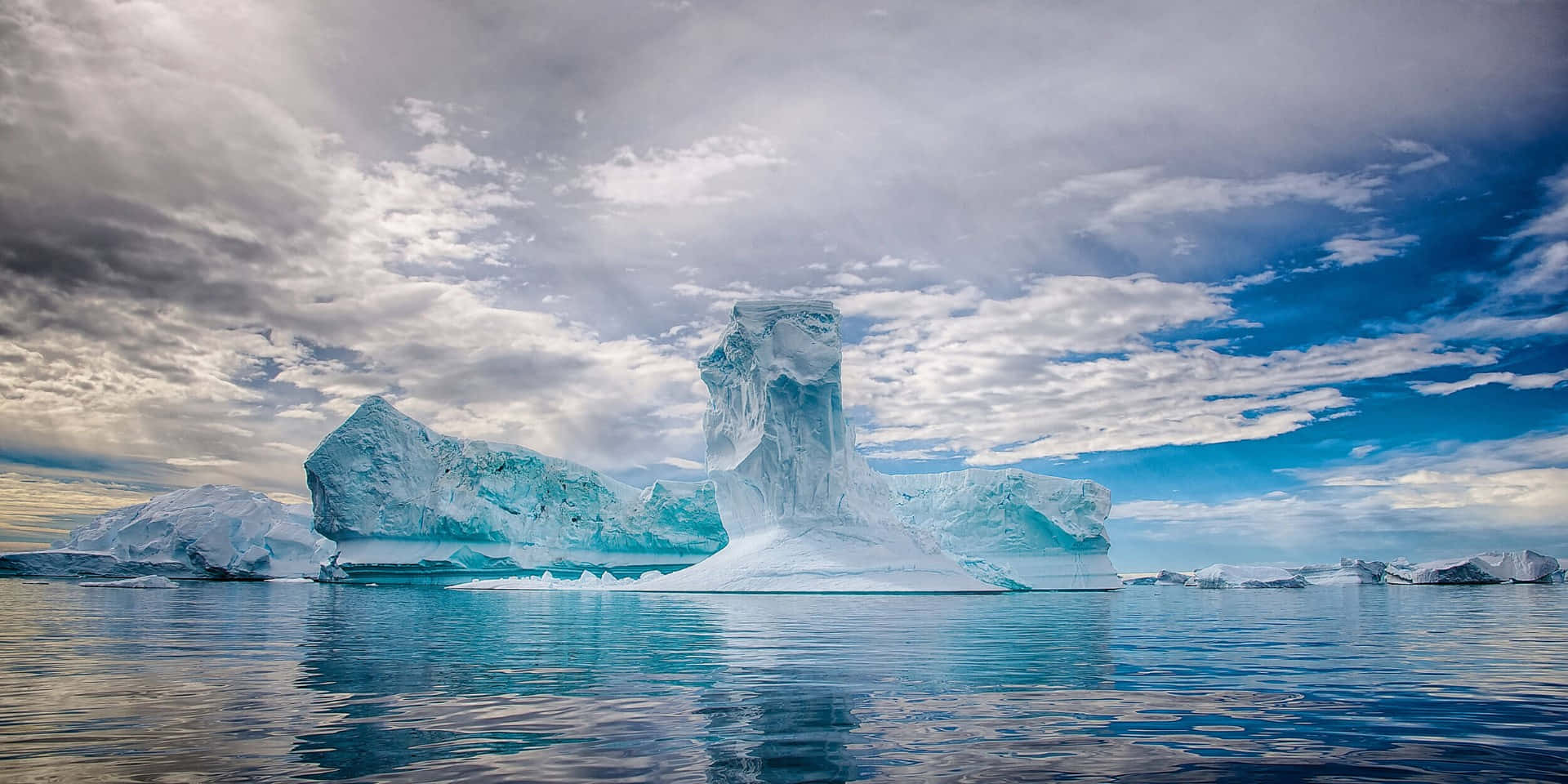 Icebergs In The Water With A Cloudy Sky