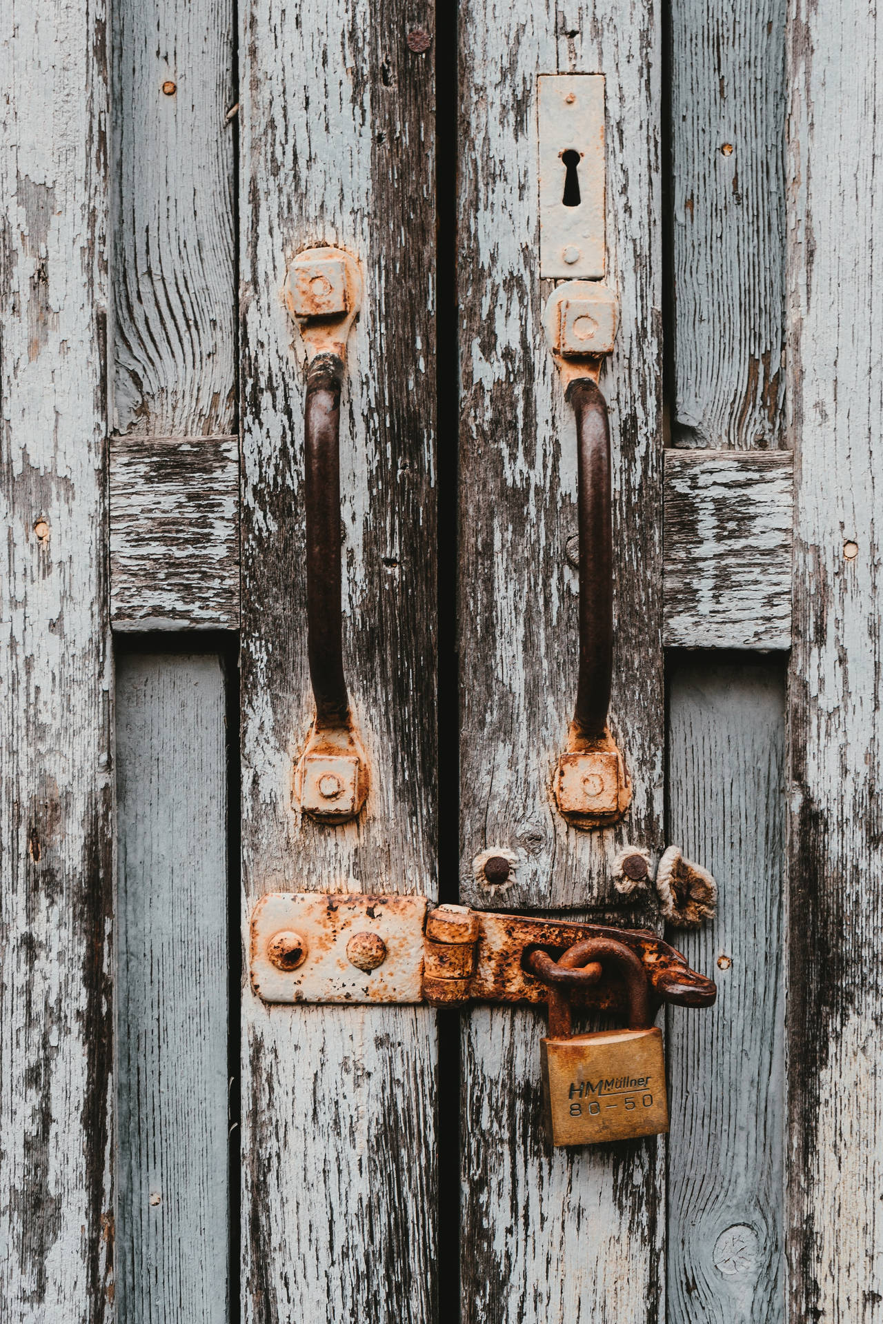 Caption: Antique Double Door with Rusted Latch Wallpaper