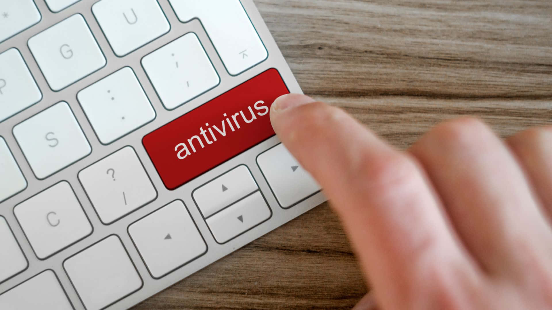 En person der trykker på en tast på tastaturet med ordet antivirus. Wallpaper