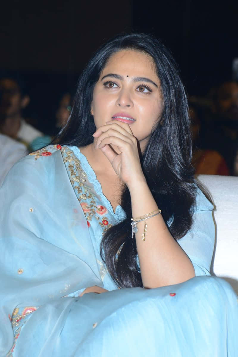 Anushka Shetty Contemplatieve Blik Op Evenement Achtergrond