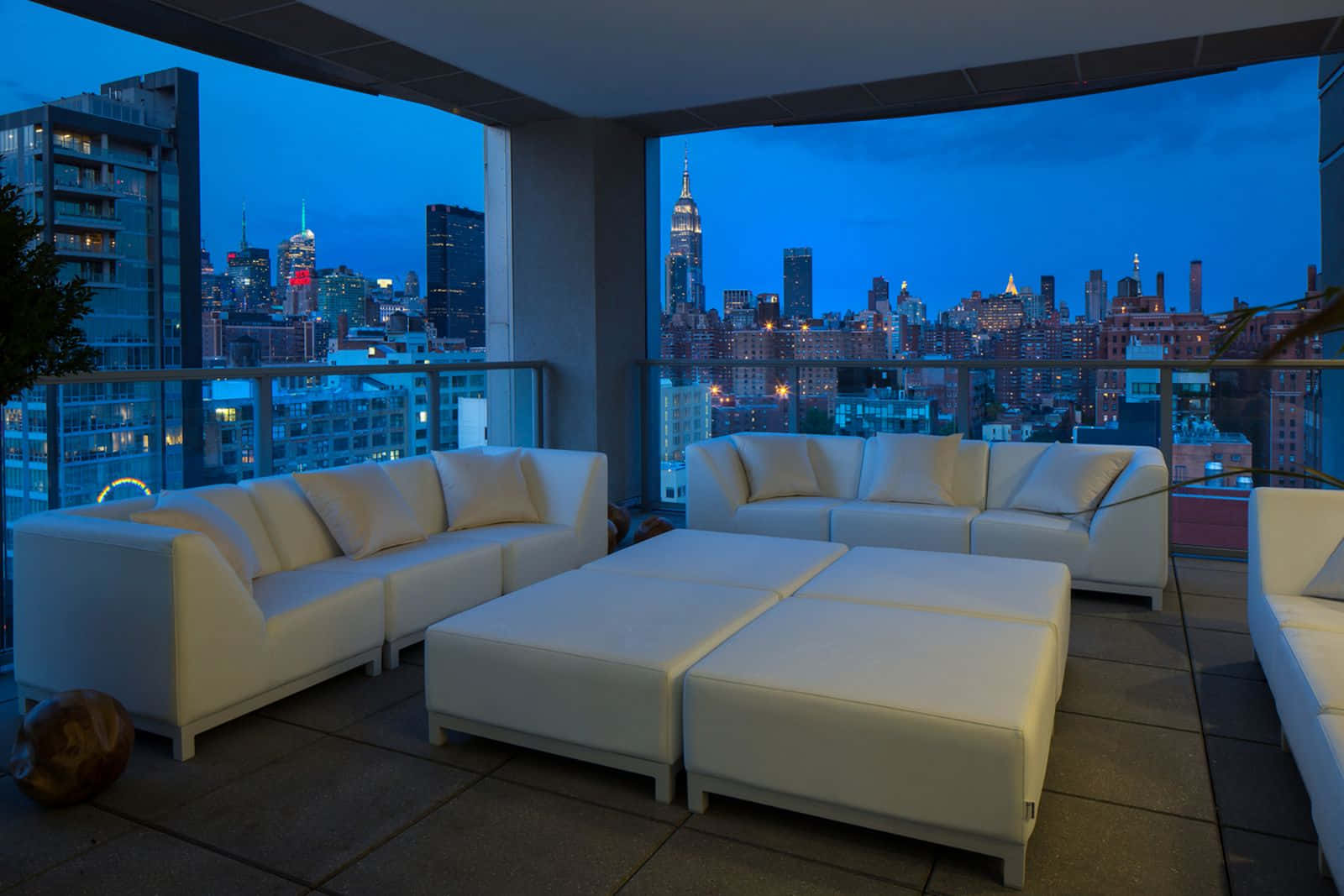 A Balcony With White Furniture And A View Of The City