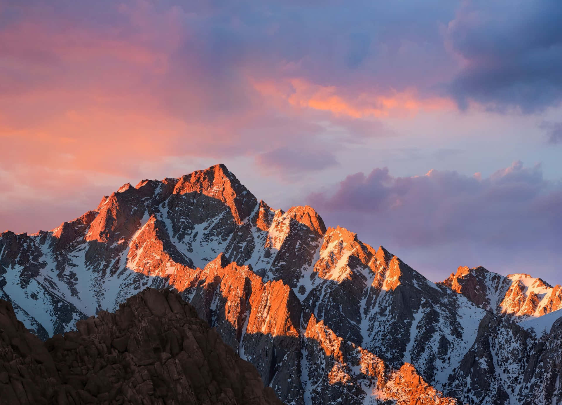 A Mountain Range With A Sunset In The Background Wallpaper