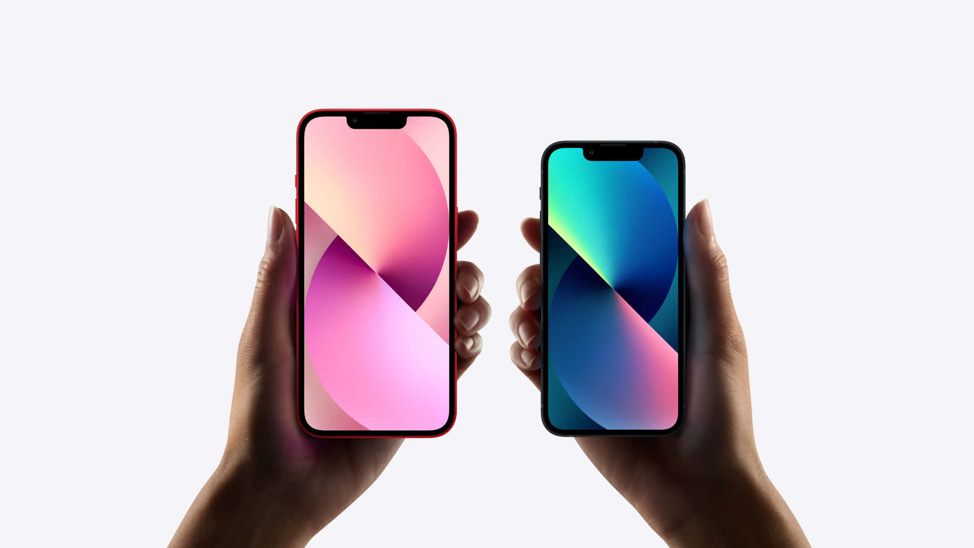 Two Hands Holding Two Iphones On A White Background