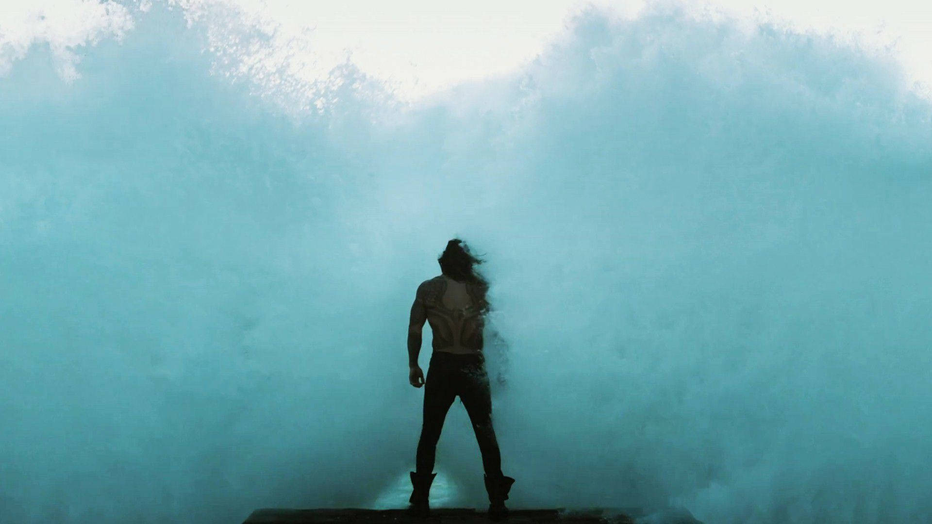 Aquaman Standing Against Waves Background