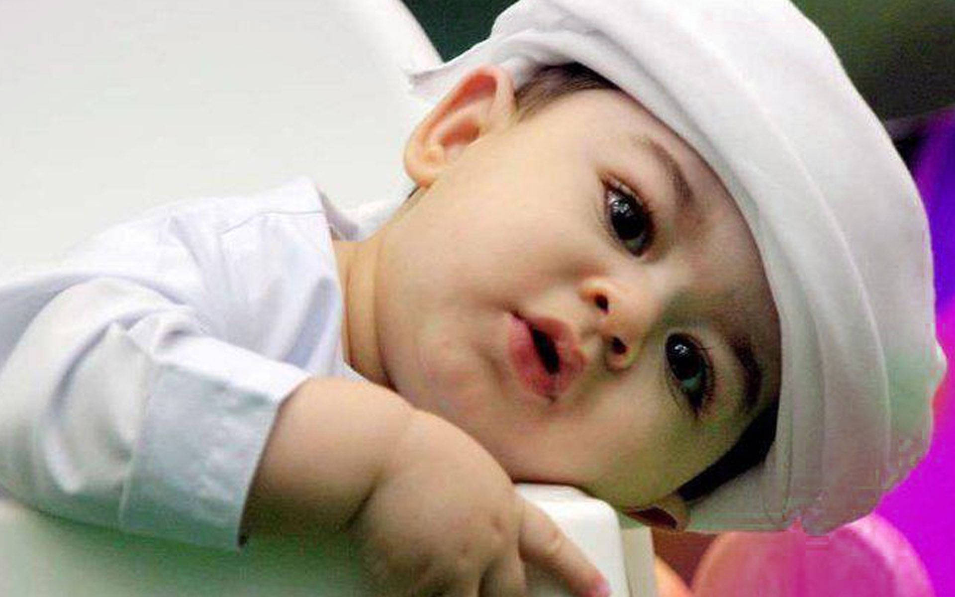 An adorable Arab baby boy wearing white Wallpaper