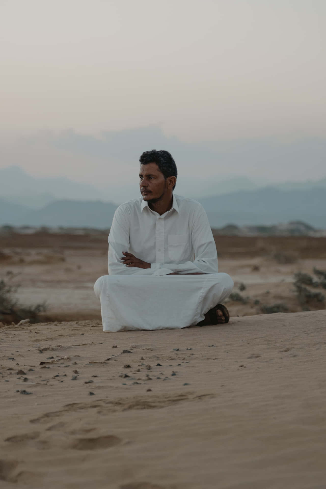 Arab Man Sitting In Desert Wallpaper