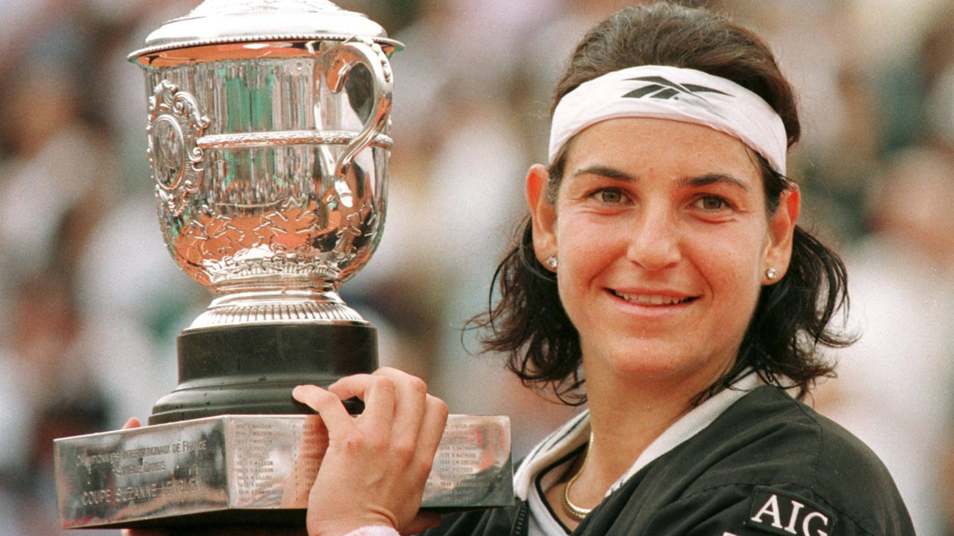 Arantxa Sanchez Vicario triumphantly lifts the trophy at the 1998 French Open Tennis tournament Wallpaper