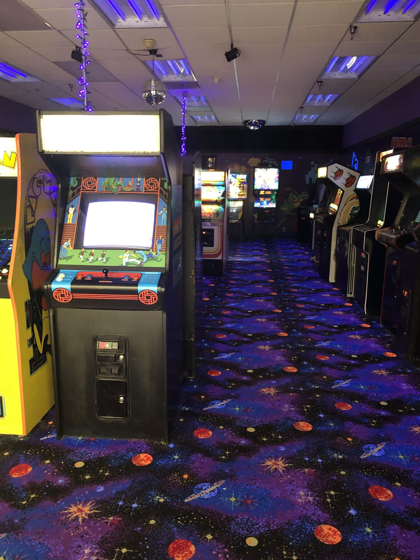 Arcade Machines In A Room With Purple Carpet Wallpaper