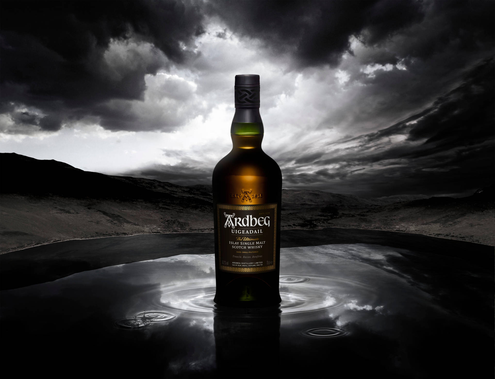 Botellade Whisky Ardbeg Uigeadail Bajo Un Cielo Tormentoso Fondo de pantalla