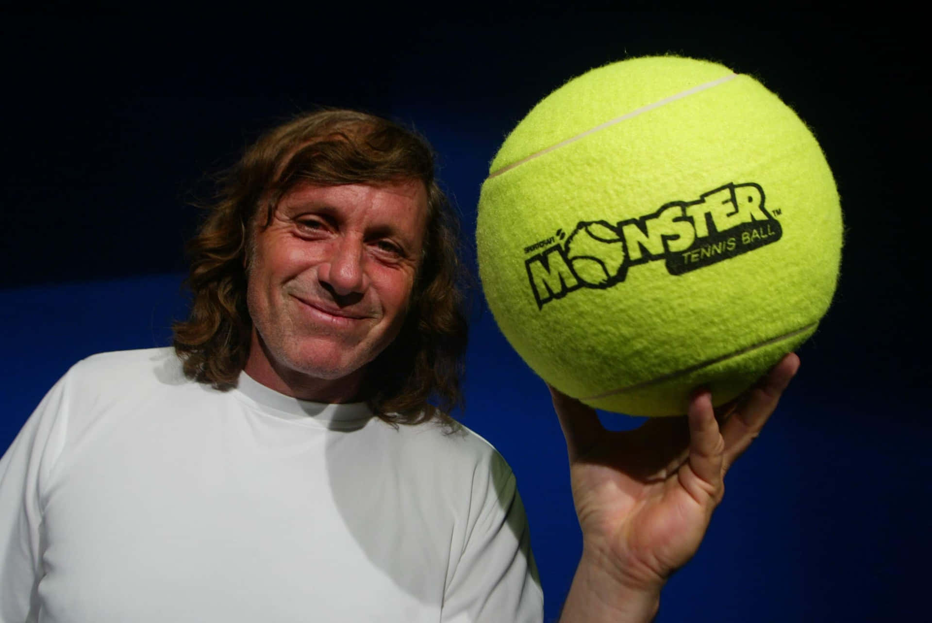 Argentine Tennis Athlete Guillermo Vilas With Giant Tennis Ball Wallpaper