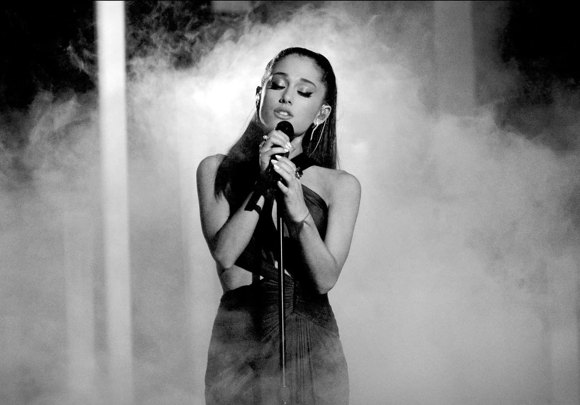 Ariana Grande singing in front of a sold-out crowd