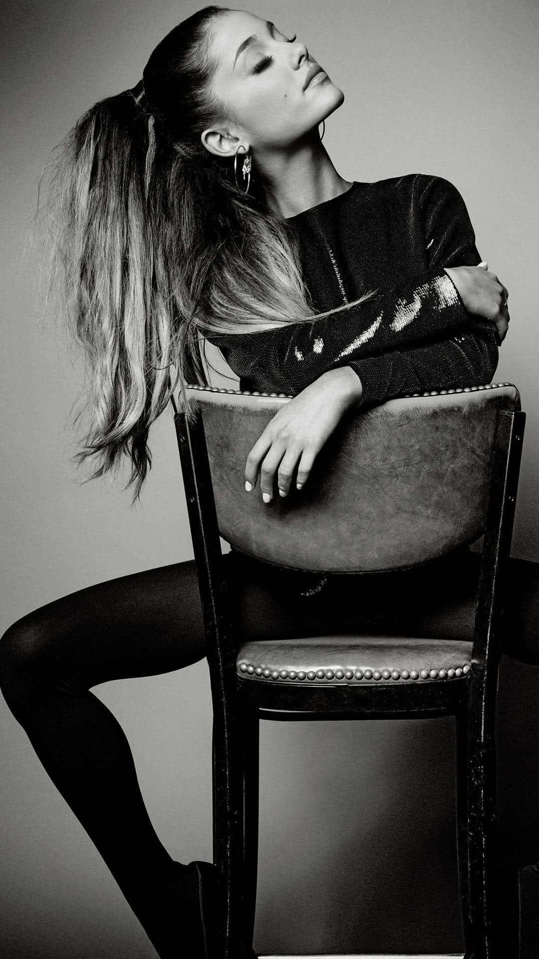 Ariana Grande Sitting On Chair Wallpaper