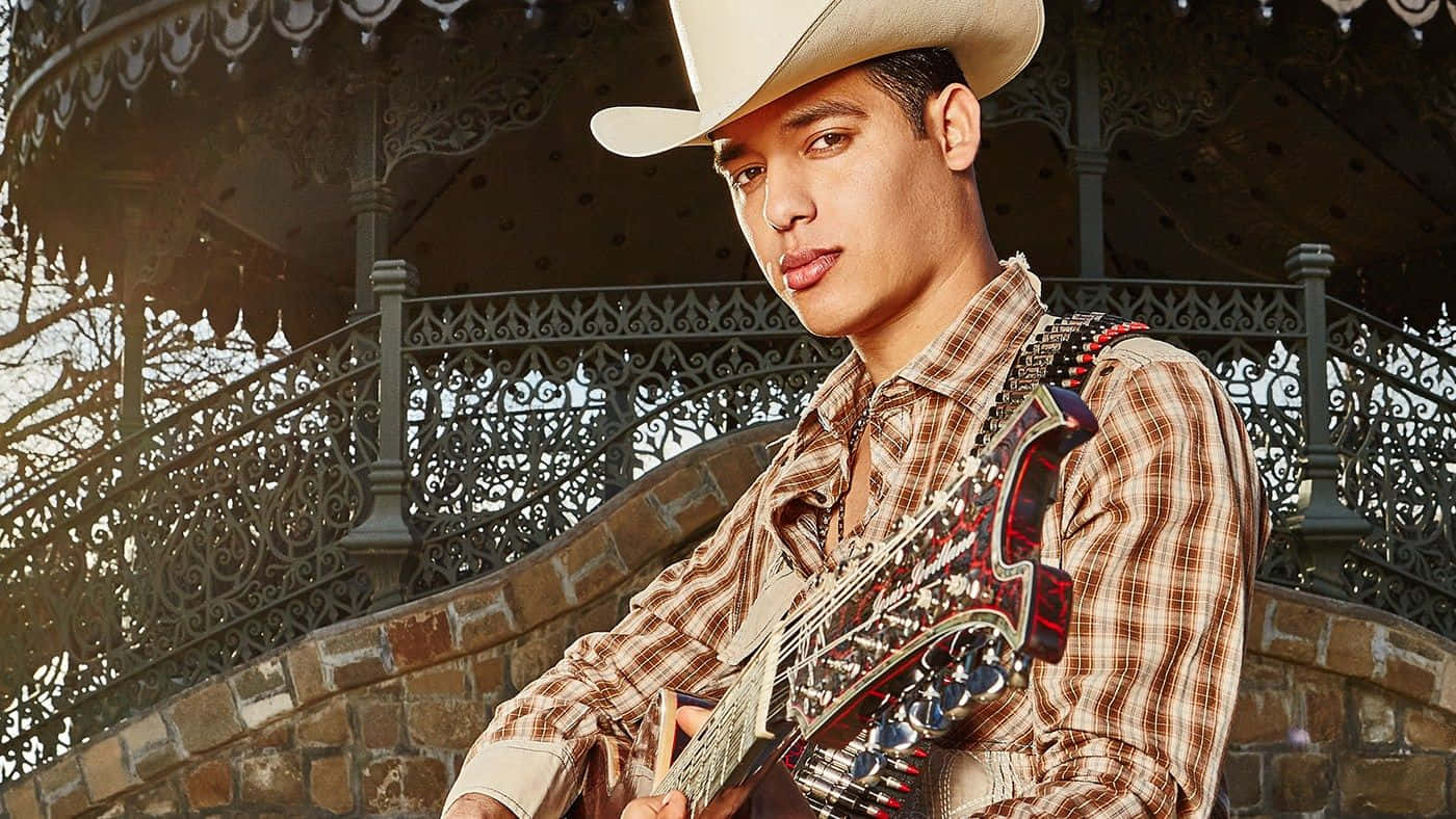 En mand med en cowboyshat holder en guitar Wallpaper