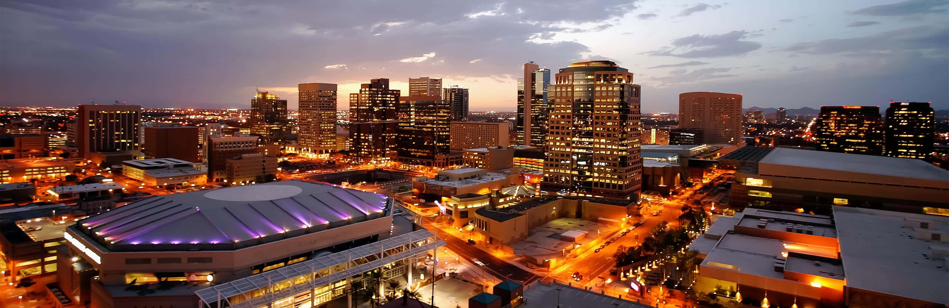 A Cityscape With Buildings And A Skyline At Night