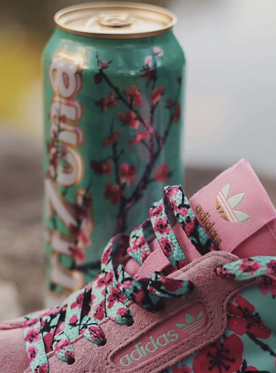 A Pink And White Adidas Sneaker With A Can Of Soda Wallpaper