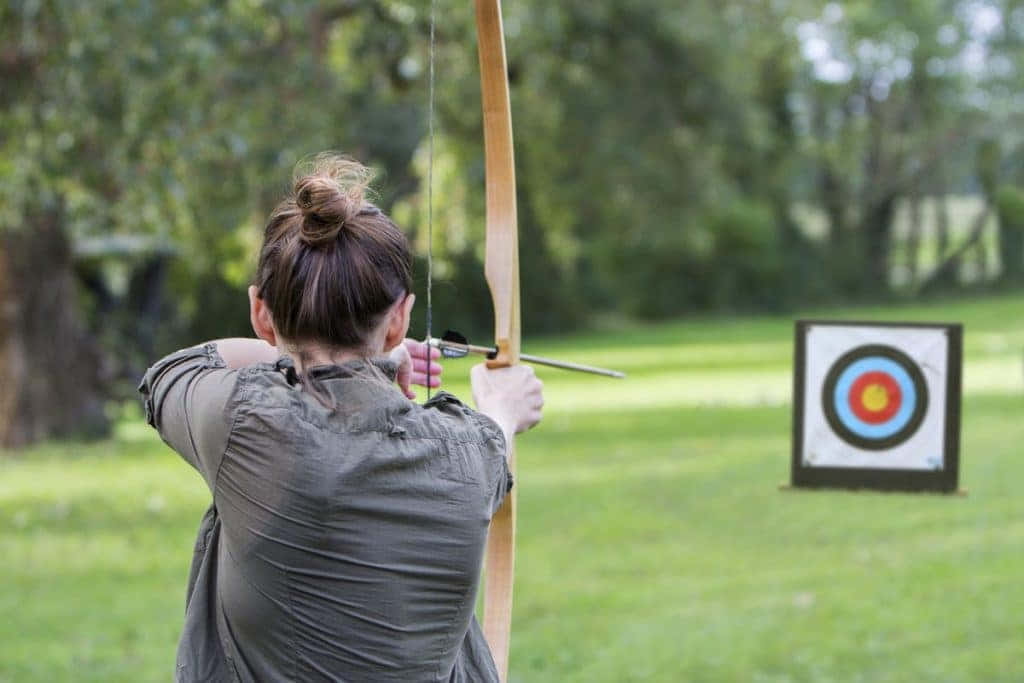 A Woman Is Aiming At An Archery Target