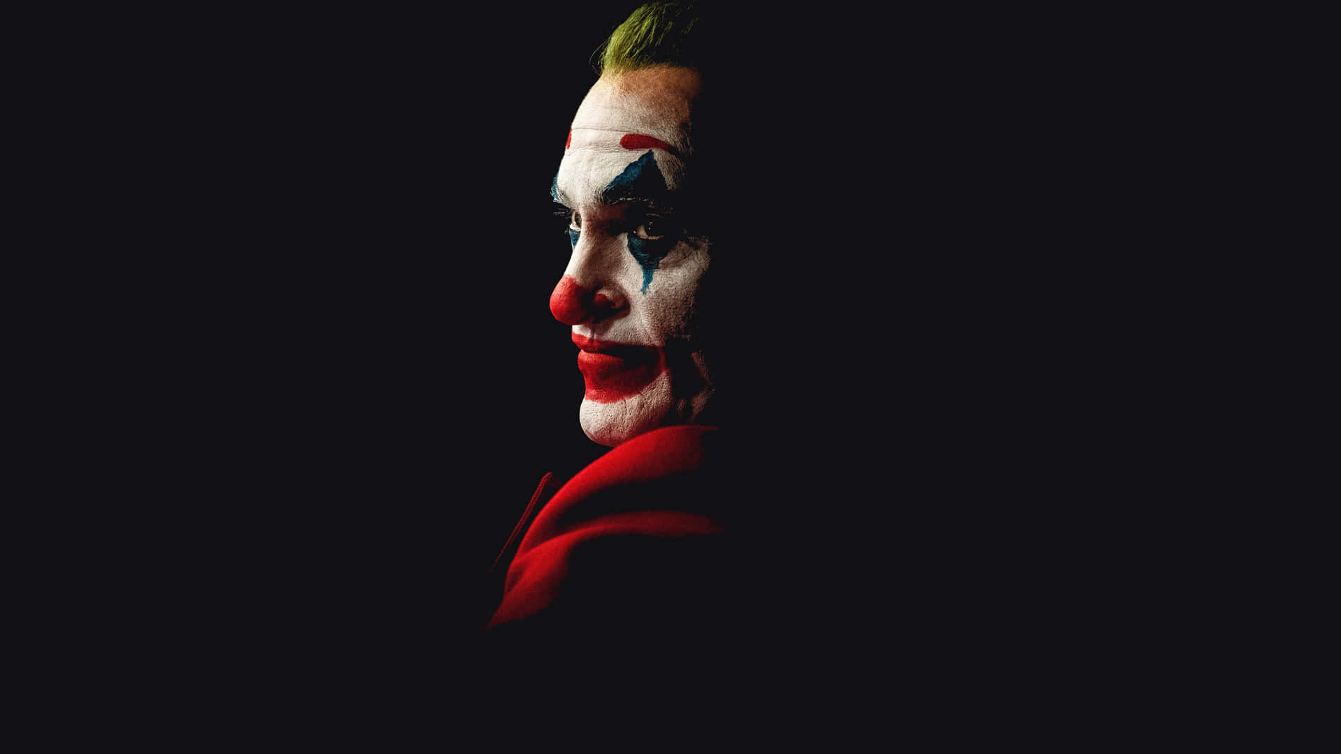 Arthur Fleck standing in his iconic Joker makeup Wallpaper
