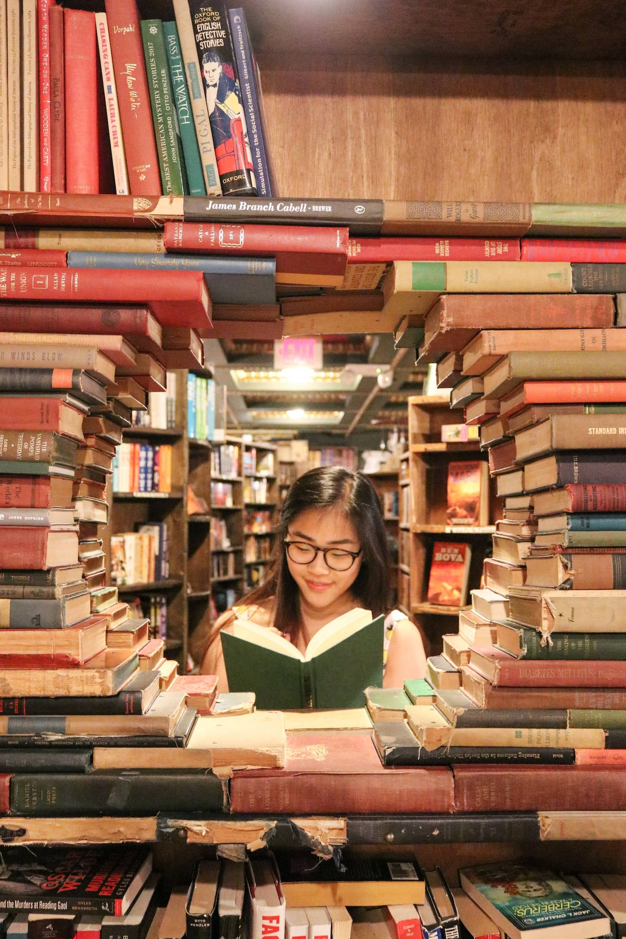Asian Teenage Girl Reading A Book In Library Wallpaper