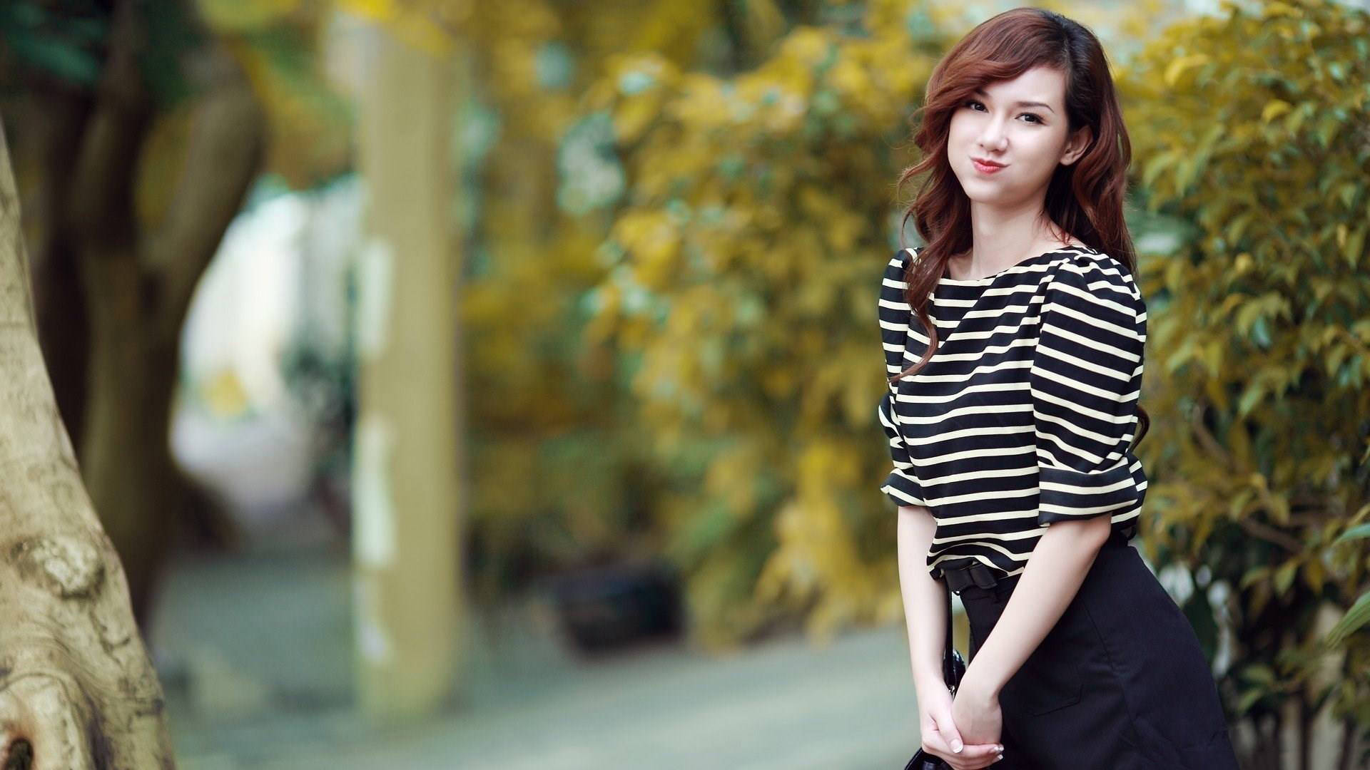 Asiatisk Kvinde Med Et Genert, Men Alligevel Sødt Smil Wallpaper