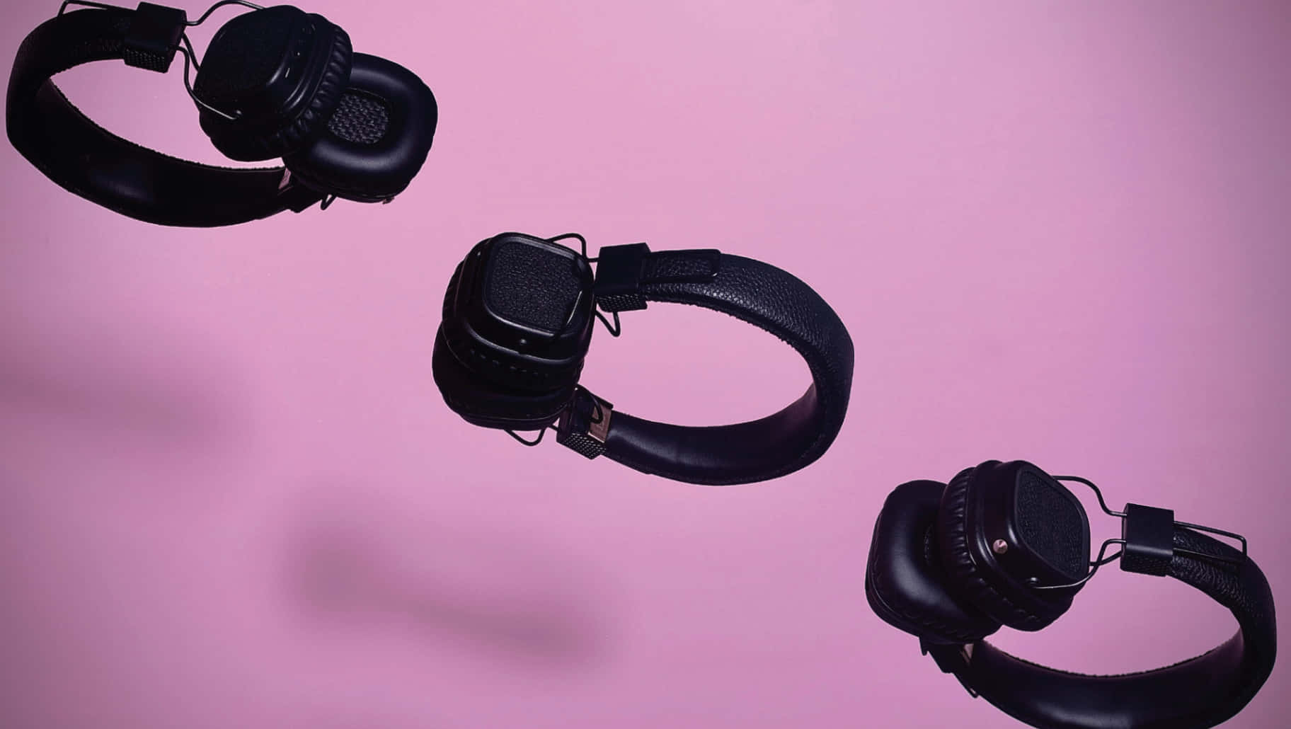 Three Black Headphones Flying In The Air Wallpaper