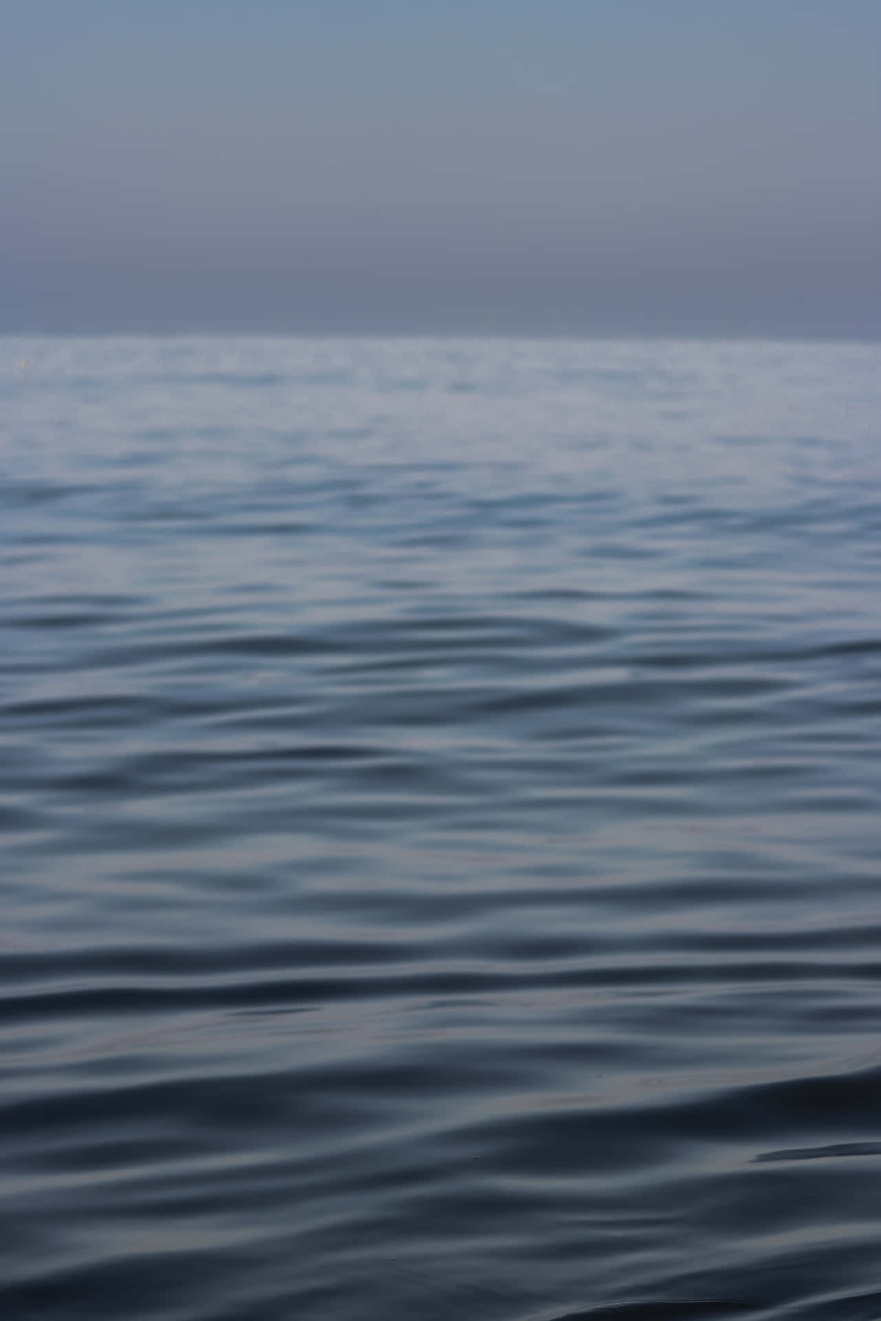 Enblå Ocean Med En Båt I Vattnet Wallpaper