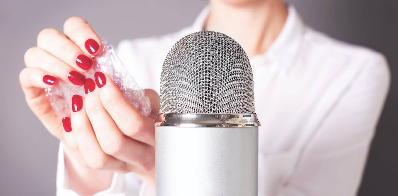 En kvinde der holder et mikrofon med sine negle på det. Wallpaper