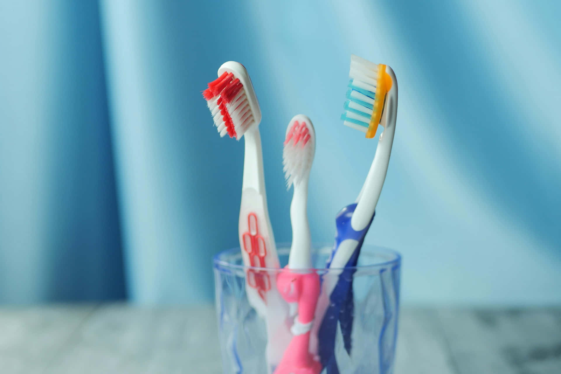 Assorted Toothbrushesin Glass Holder Wallpaper