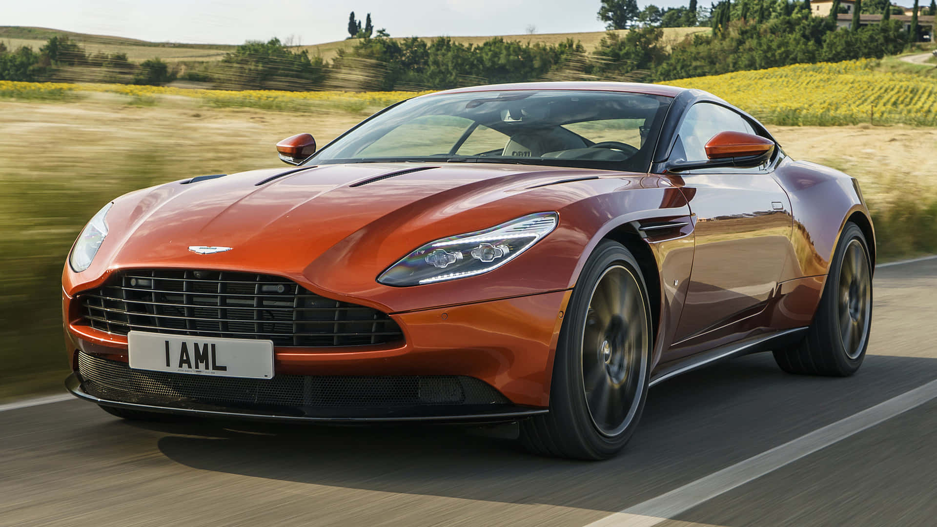 Sleek and powerful Aston Martin DB11 in motion on an open road Wallpaper